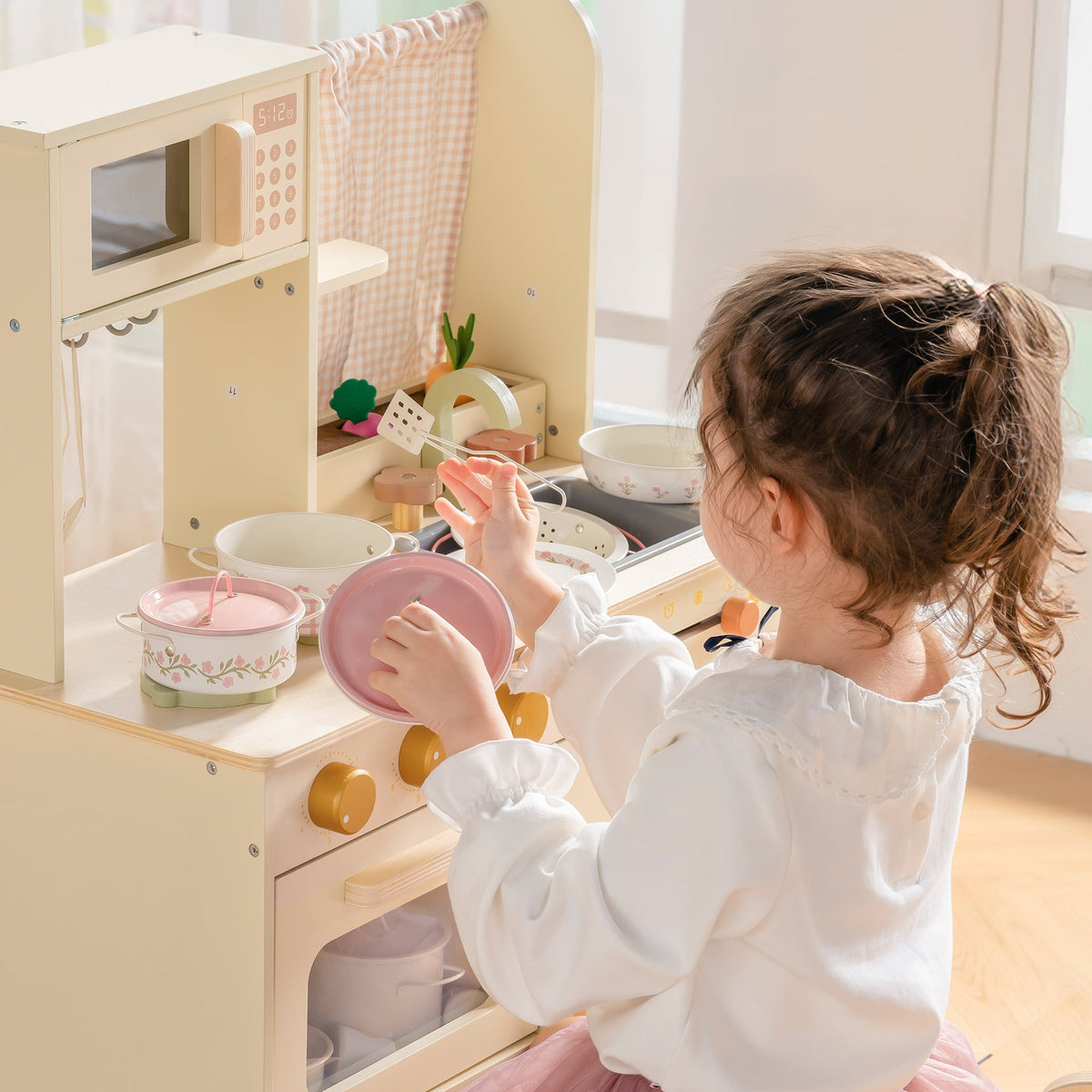 Girl in chef hat at wooden ROBUD Tinplate Pretend Cooking Utensils pink edition play kitchen stirring in pink pot on stovetop