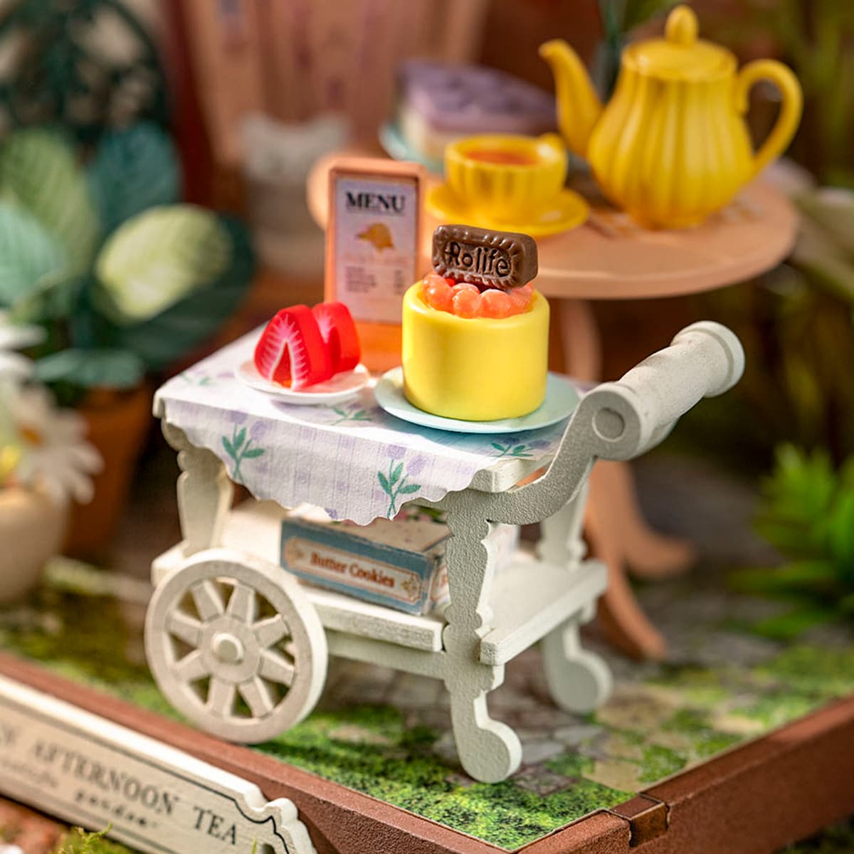 Rolife afternoon tea miniature detail showing a dessert cart with layered cake, strawberries and menu card