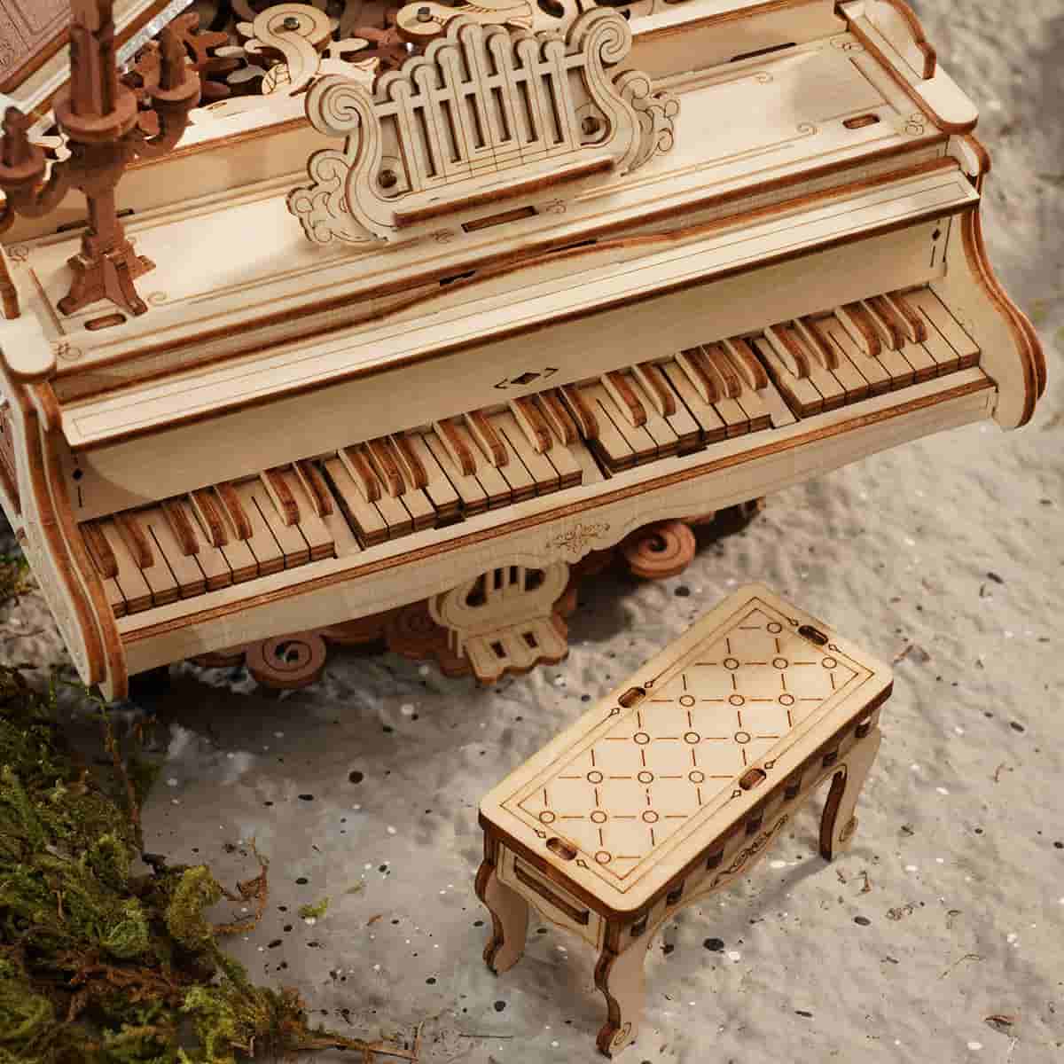 ROKR Magic Piano AMK81 close up showing crystal acrylic lid interior with wooden flower spinner visible through the transparent top in sunlight