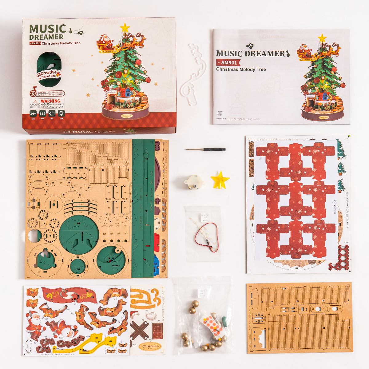 Rolife Christmas Melody Tree AMS01 flat-lay kit view showing laser-cut wooden boards music mechanism hardware stickers and instruction booklet