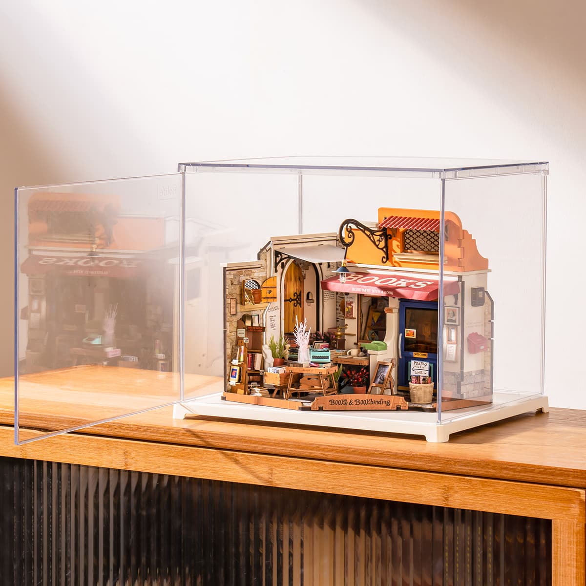 Rolife Corner Bookstore in a clear display box is shown at an angle on a cabinet.