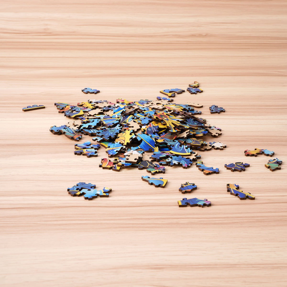 Rowood Morpho Helena wooden puzzle pieces scattered on a light wooden surface before assembly, showing colorful fragment details.