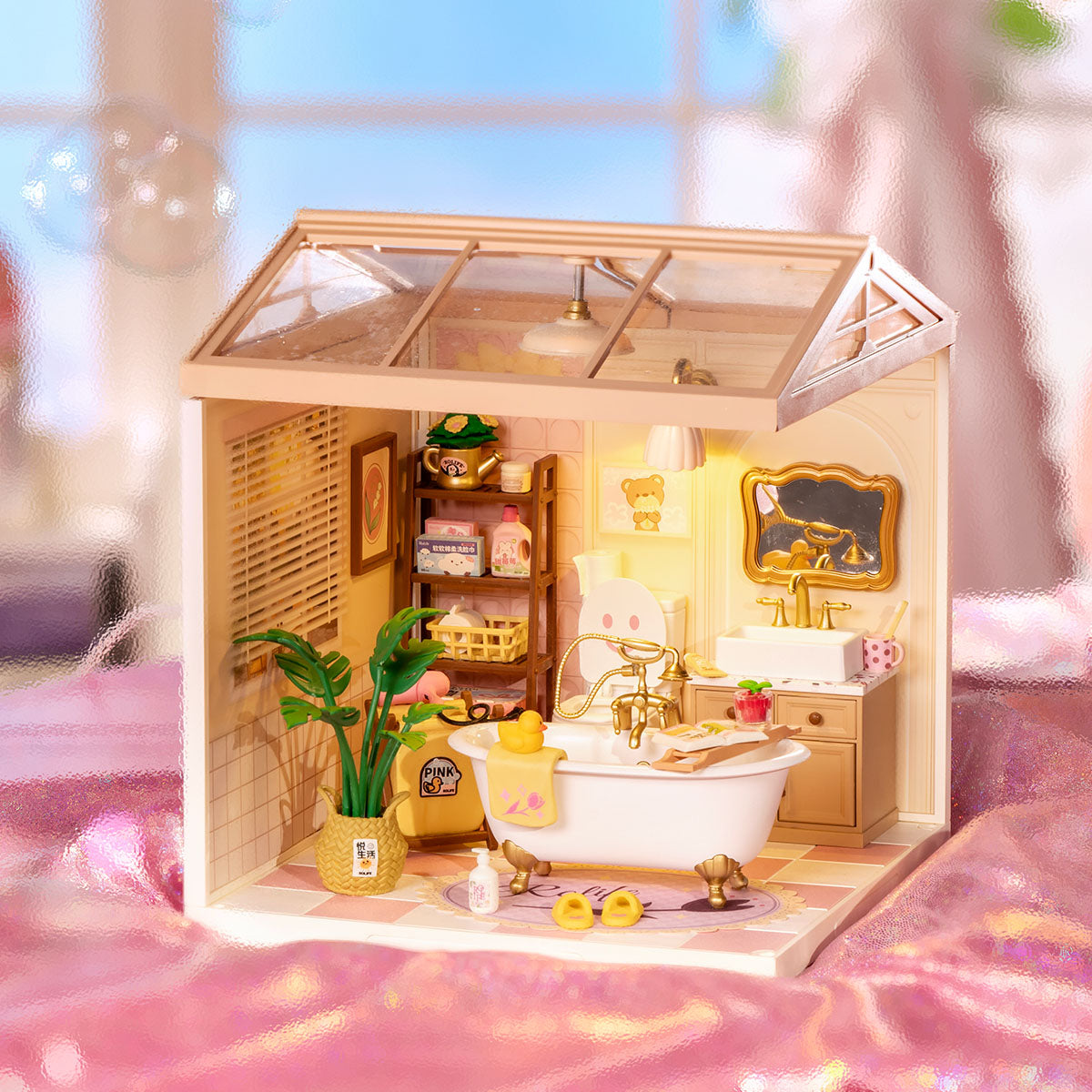 Rolife Pop Bubble Bathroom miniature room displayed on a pink fabric surface with warm lighting