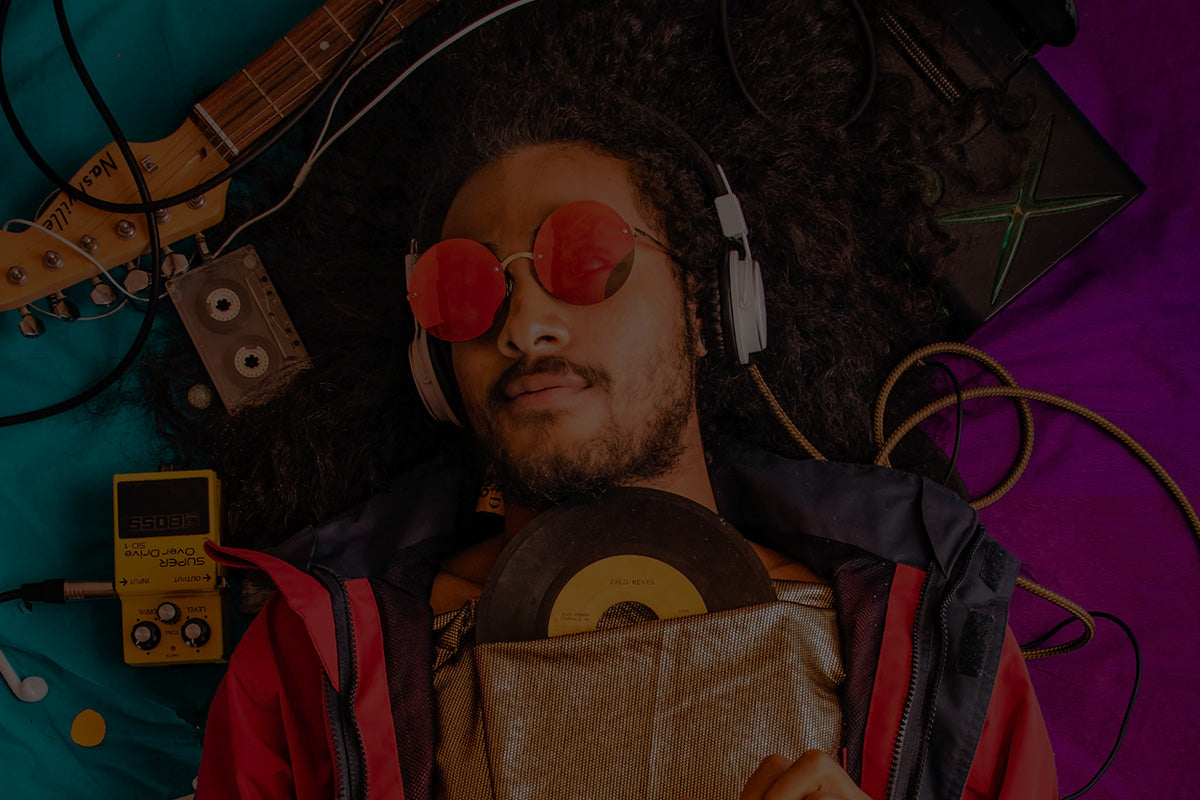 Robotime Online Gifts for Music Lovers, man with headphones and red sunglasses among guitar, vinyl and cassette tape