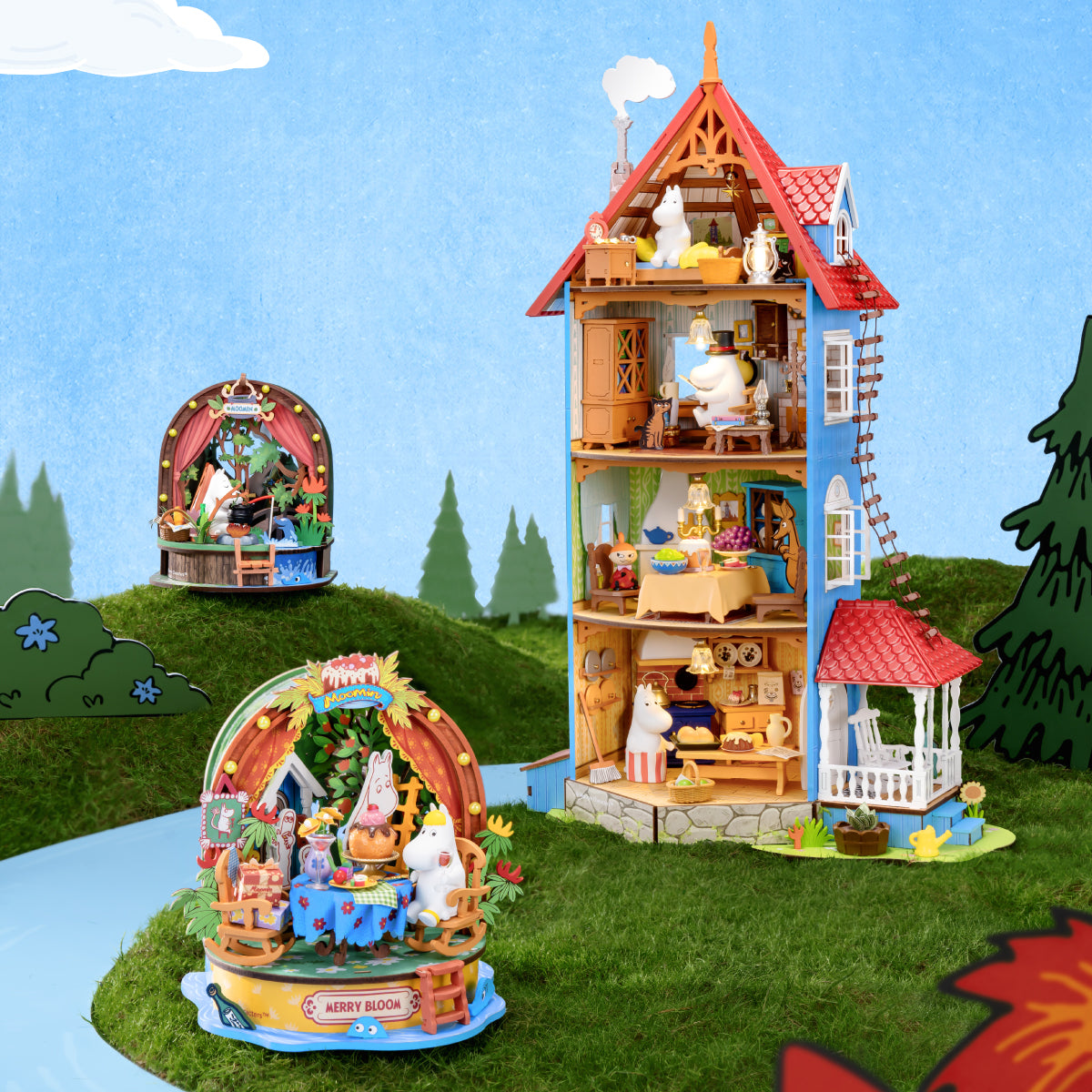 Three Happy Life in Moominvalley miniature scenes arranged on an illustrated lawn