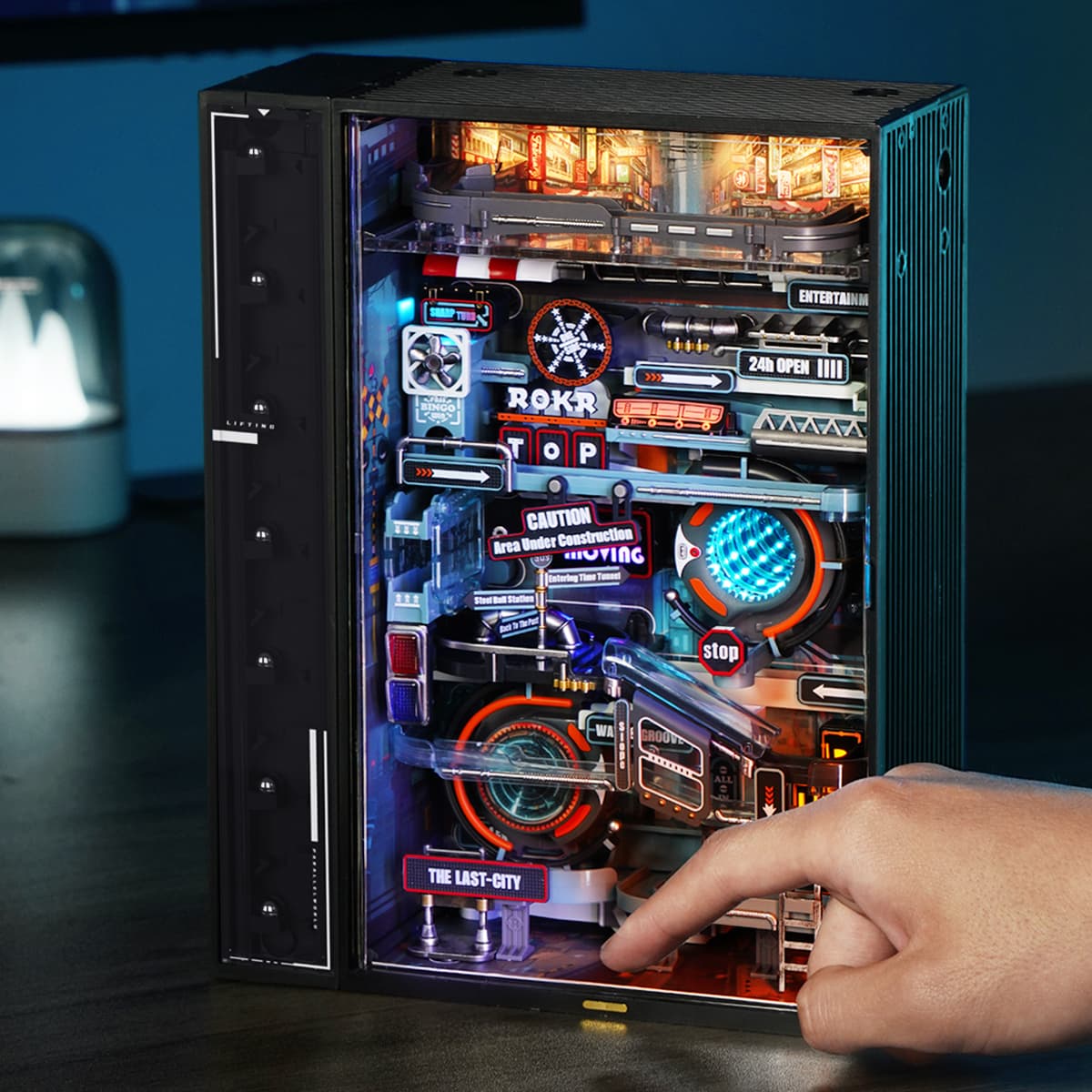 ROKR Parallel World Marble Run MR02S front-opening black cabinet illuminated with blue and orange neon lights showing The Last City cityscape backdrop