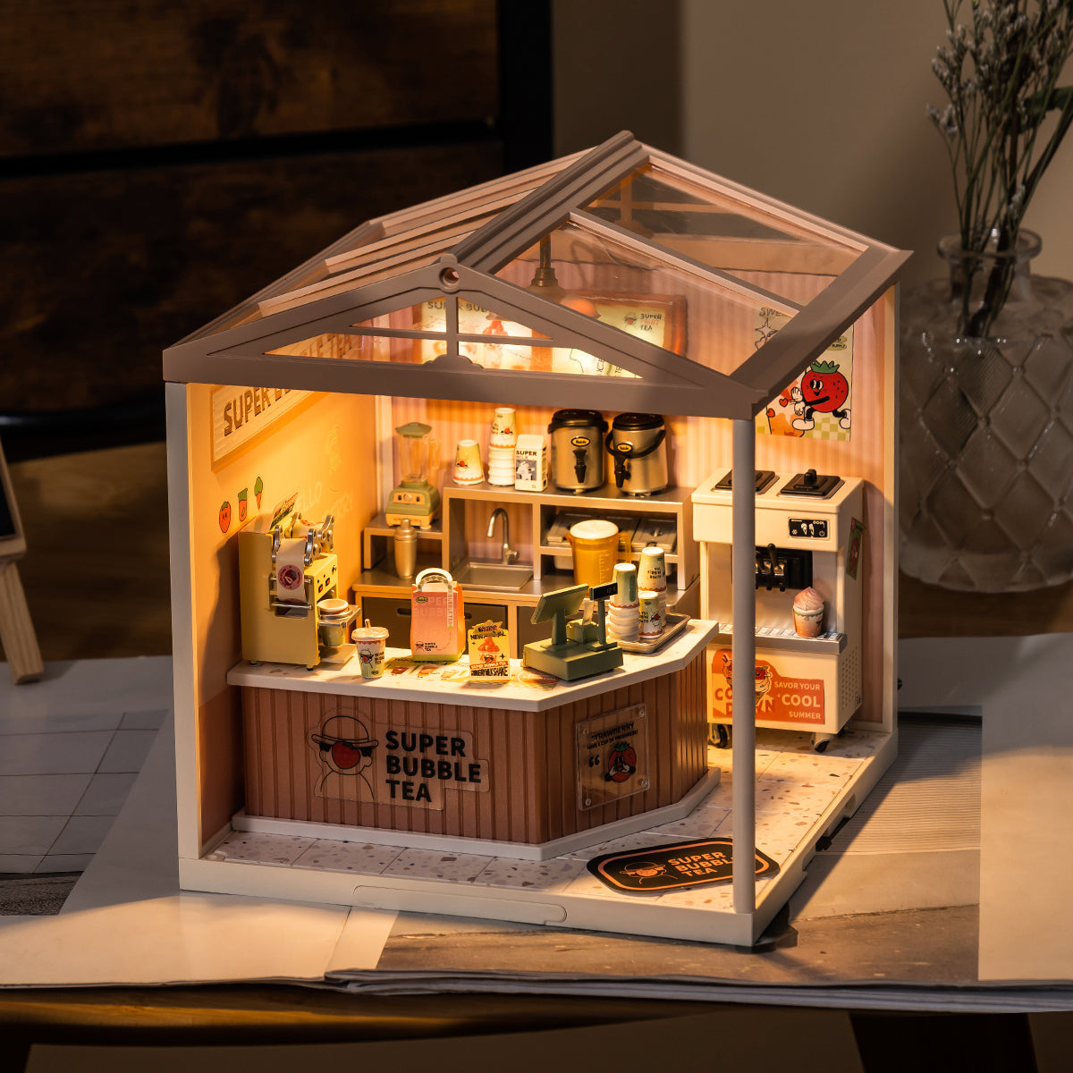 Rolife lit miniature house shows a cozy glass roof room with tiny furniture and warm interior lights.