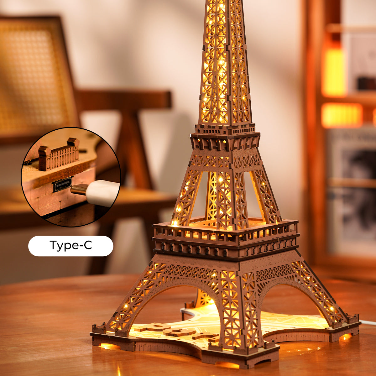 Rolife Eiffel Tower wooden model glowing with warm LED lights on a table, with inset showing the Type-C USB charging port