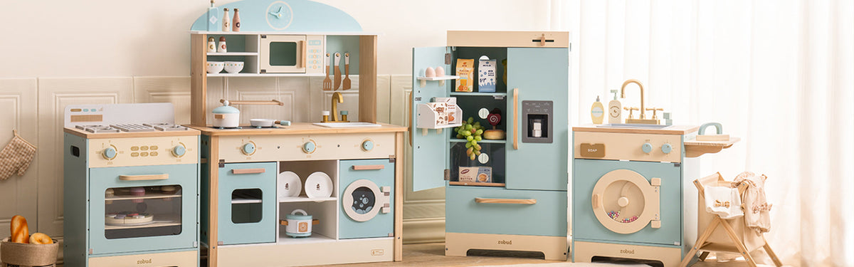 ROBUD blue and natural wood play kitchen set collection showing oven range, main kitchen unit, refrigerator, and washing machine in a bright room setting