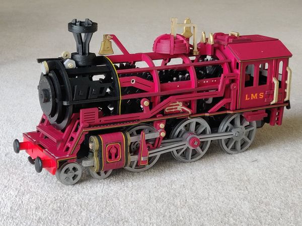 Robotime pink steam locomotive model has a black boiler and silver wheels.