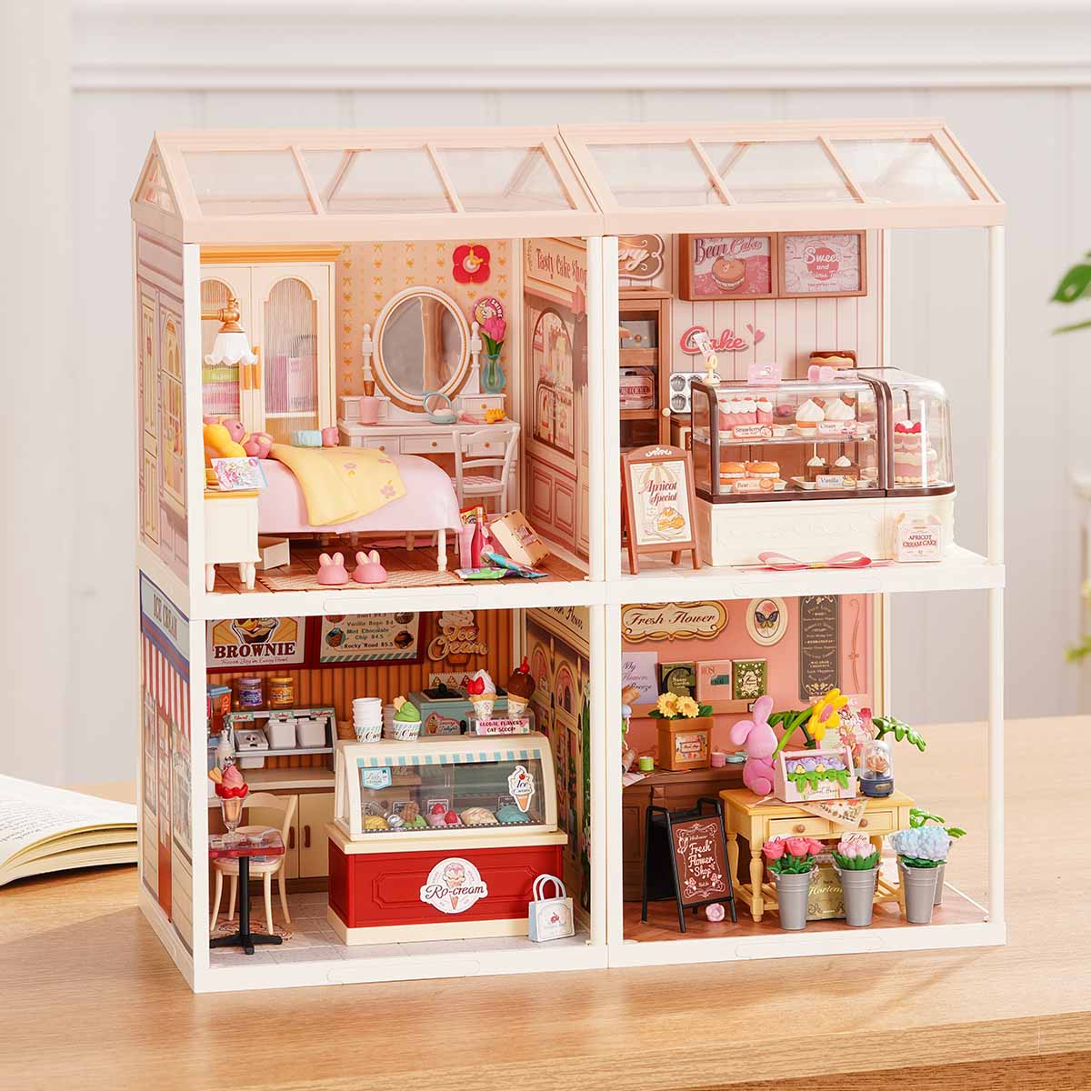 Rolife Super Creator Series 4-in-1 Four Grid miniature with bakery, bookstore, Rolife Bar, and bubble tea shop arranged in a two-by-two grid with swing and umbrella deck on a desk.