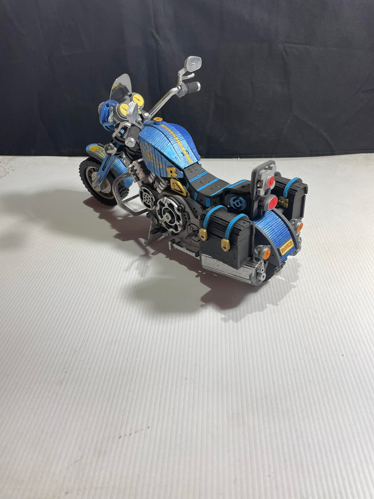 Robotime blue race car model has exposed gears and a low body on a light surface.