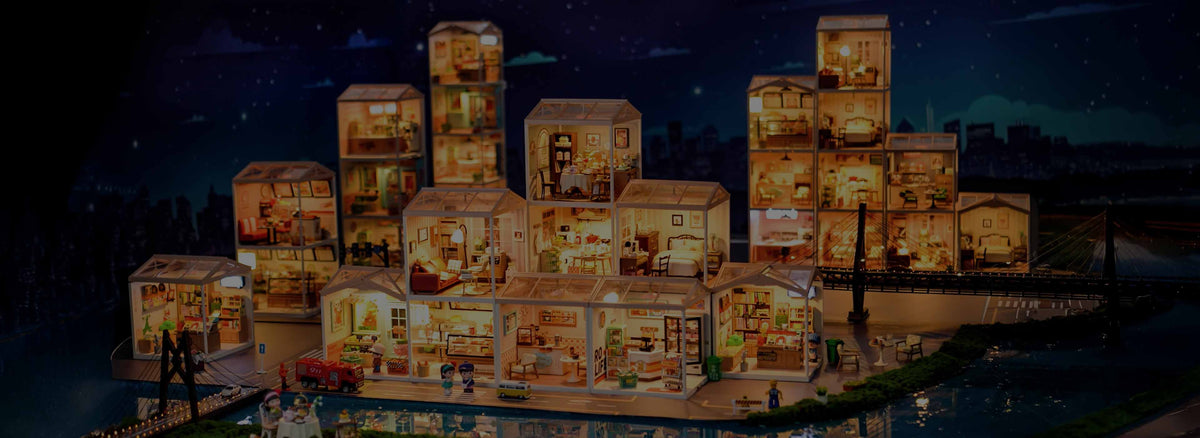 Robotime wide desktop banner showing a glowing Rolife miniature city composed of illuminated dollhouses arranged along a nighttime waterfront with reflections