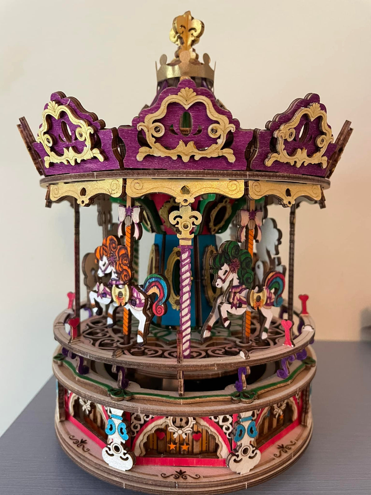 Robotime carousel model has a purple canopy, gold trim, and small animal figures.