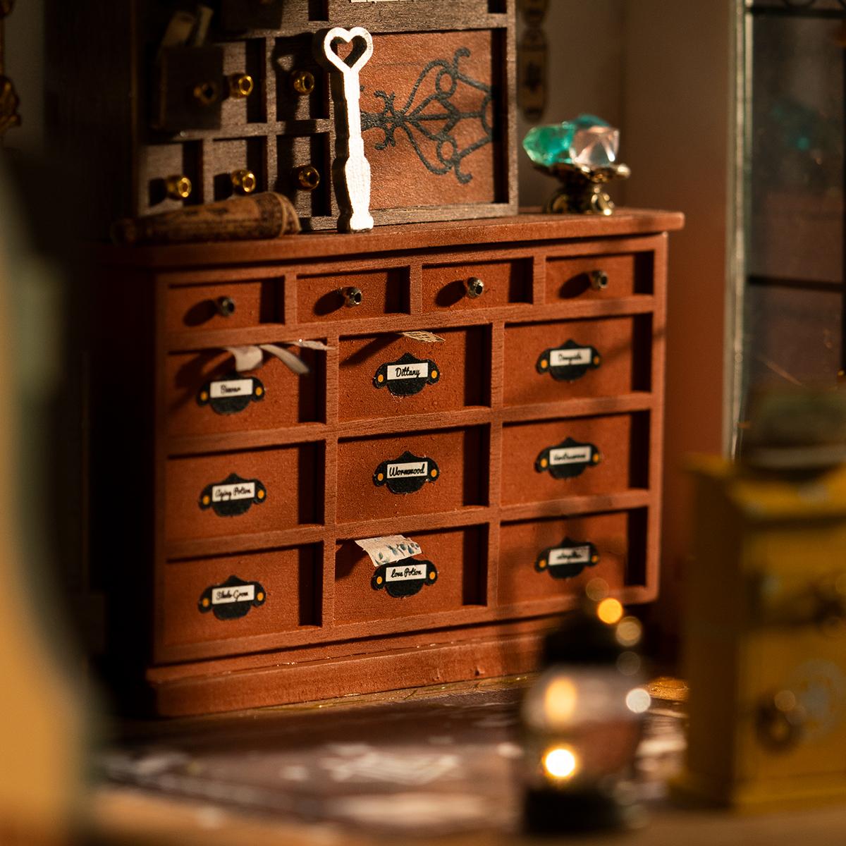 Rolife Kiki's Magic Emporium miniature house DG155 detail view showing hand-assembled tiny furniture, cauldron, and magical shop props