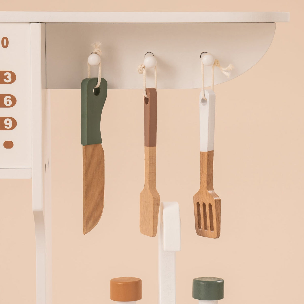 ROBUD vintage green wooden play kitchen WCF04 detail showing three wooden utensils hanging on white wall hooks