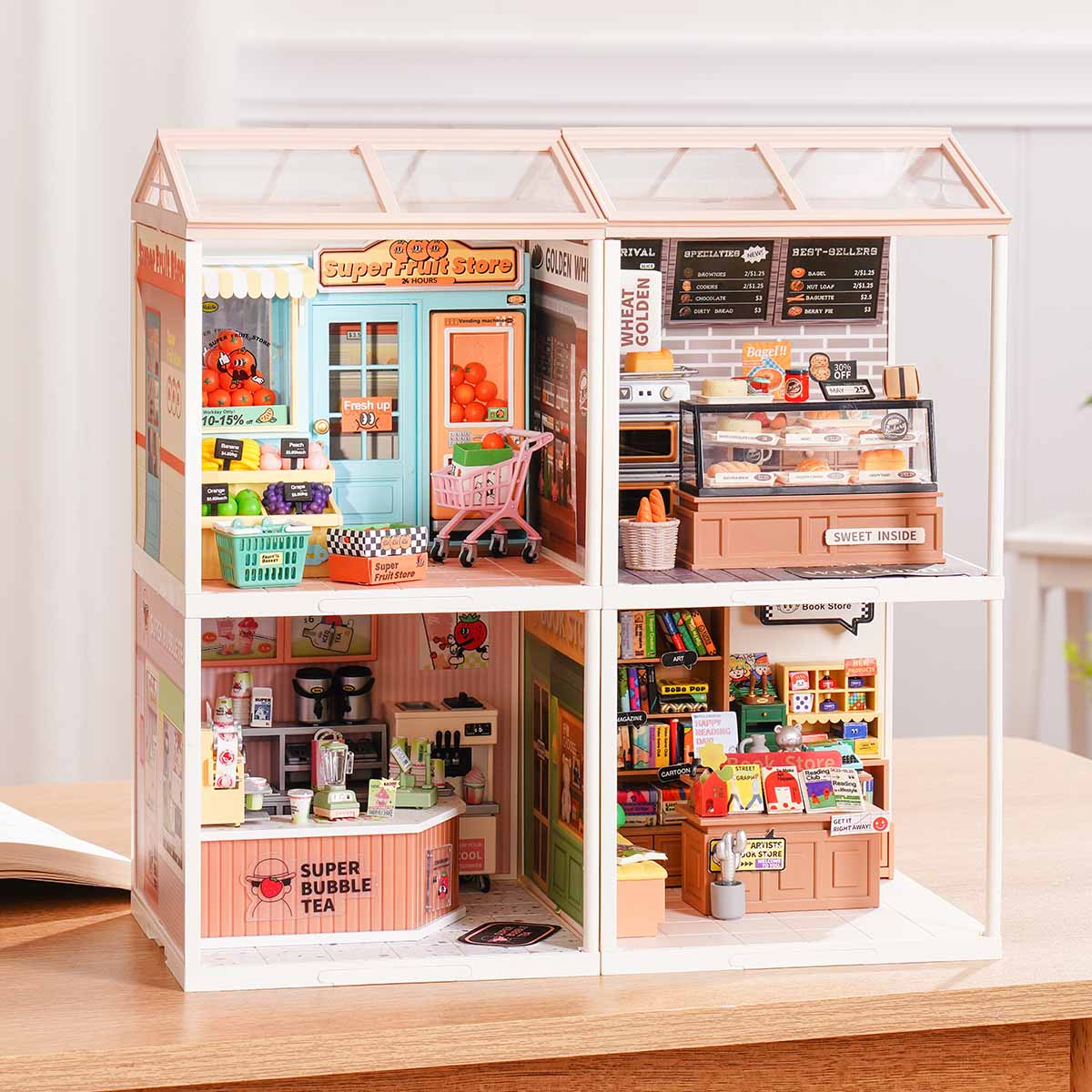 Rolife Super Creator Series 4-in-1 Four Grid miniature showing Super Fruit Store, Wheat Golden Bakery, Super Bubble Tea, and an art bookstore in four grid cells on a wooden surface.