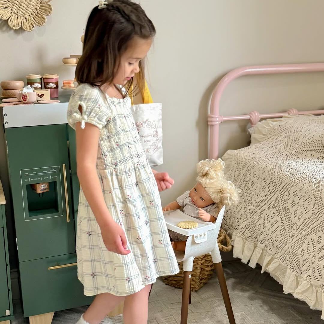 Young girl in floral dress standing beside ROBUD vintage green play kitchen refrigerator in a cozy cream and pink bedroom
