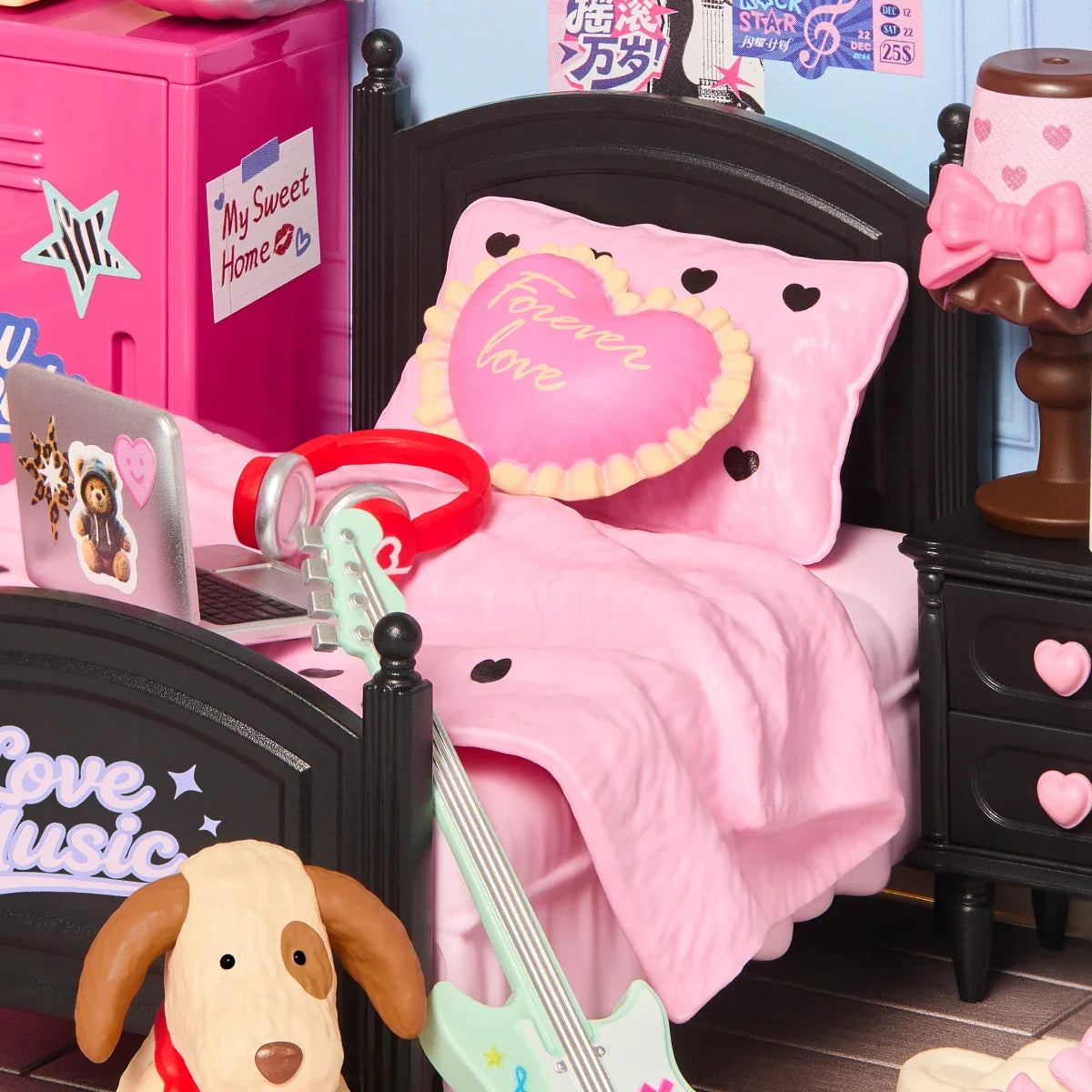 Nahaufnahme eines Rolife-Miniatur-Schlafzimmers mit schwarzem Bett, rosa Bettwäsche, herzförmigem „Forever Love“-Kissen, roten Kopfhörern, Laptop, Gitarre und Hundefigur.